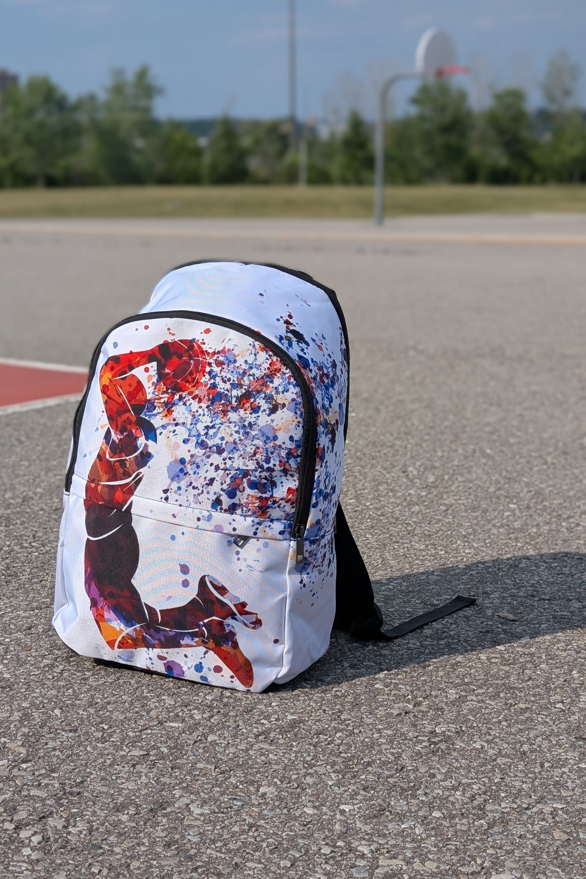 Backpack with colorful splatter design on a concrete surface