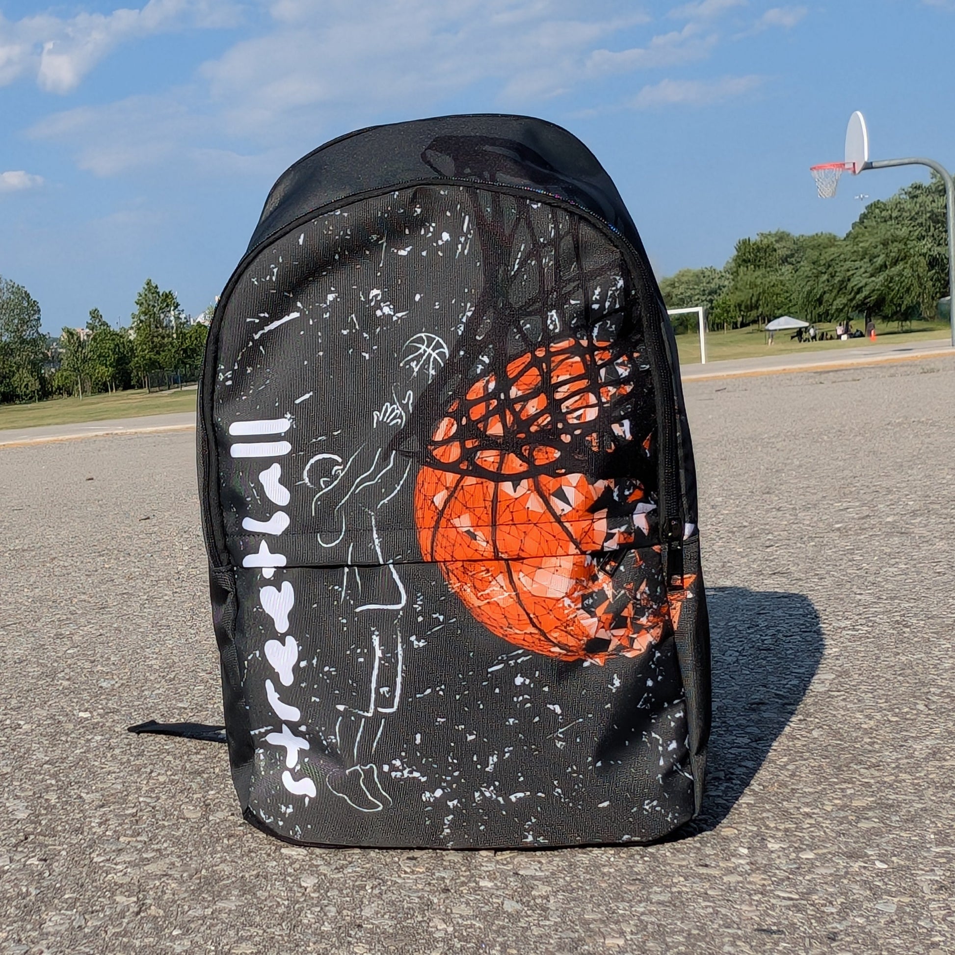 Front view backpack with chalk drawing of a man shooting a basketball beside the word streetball.  Beside it a large basketball going through a net on a basketball court