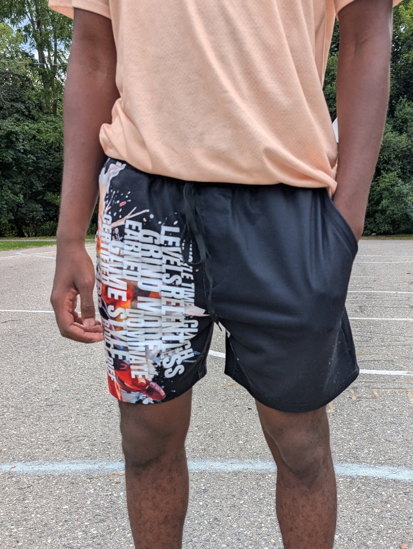 Person wearing colorful shorts and black sneakers on a basketball court