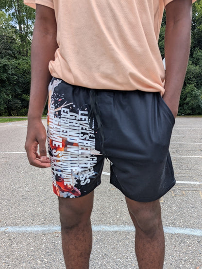 Person wearing colorful shorts and black sneakers on a basketball court