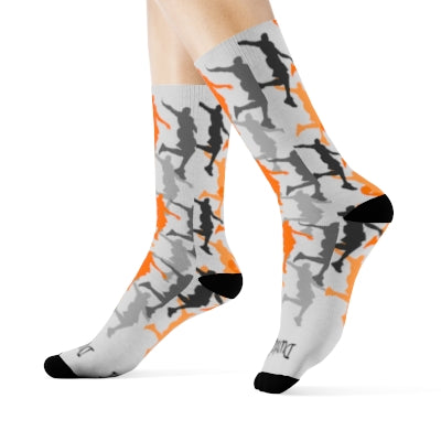 Side profile of white athletic socks with orange, black and grey dunking silhouettes printed all over. Black patches on the heels