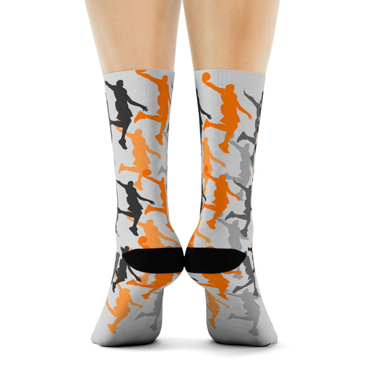 White athletic socks with orange, black and grey dunking silhouettes printed all over. Black patches on the heels