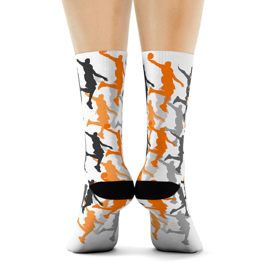 Back profile of white socks with black, grey and orange dunking silhouettes. Black heels